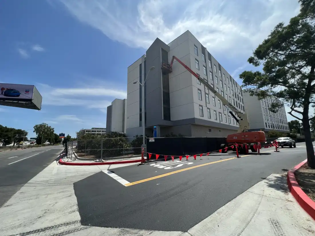 Multi-story institutional building with a crew working from a boom lift